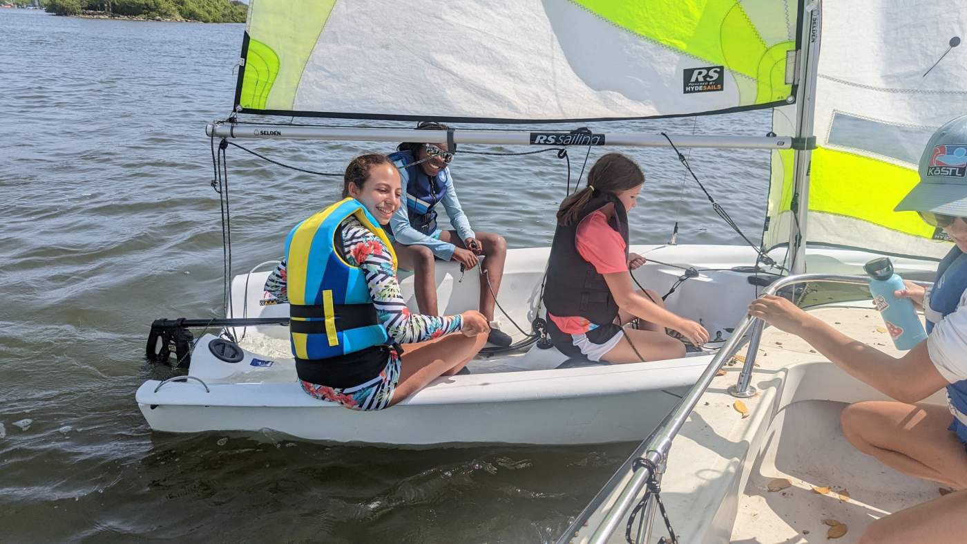 Three girls sailing a boat