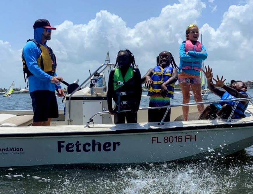 A group of children and an instructor in a powerboat