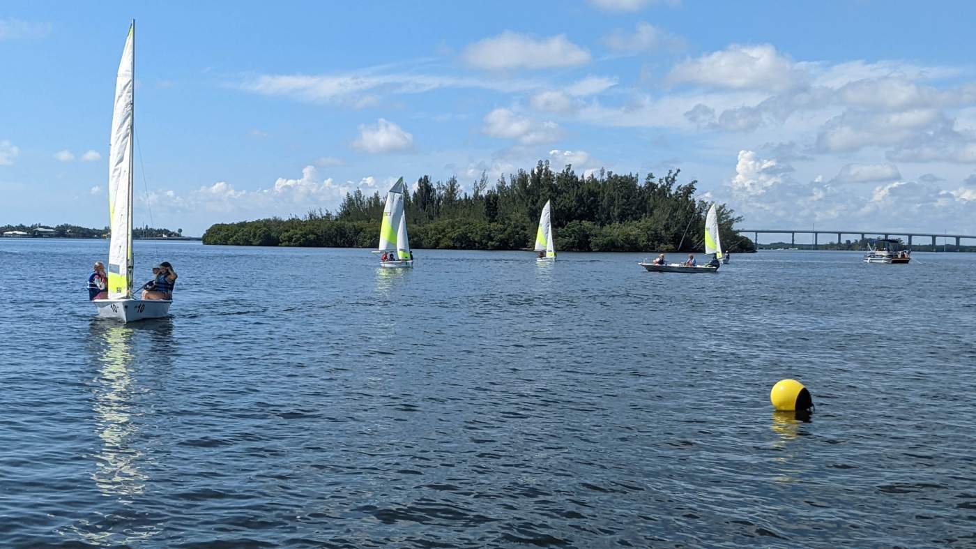 Four sailboats approaching a buoy