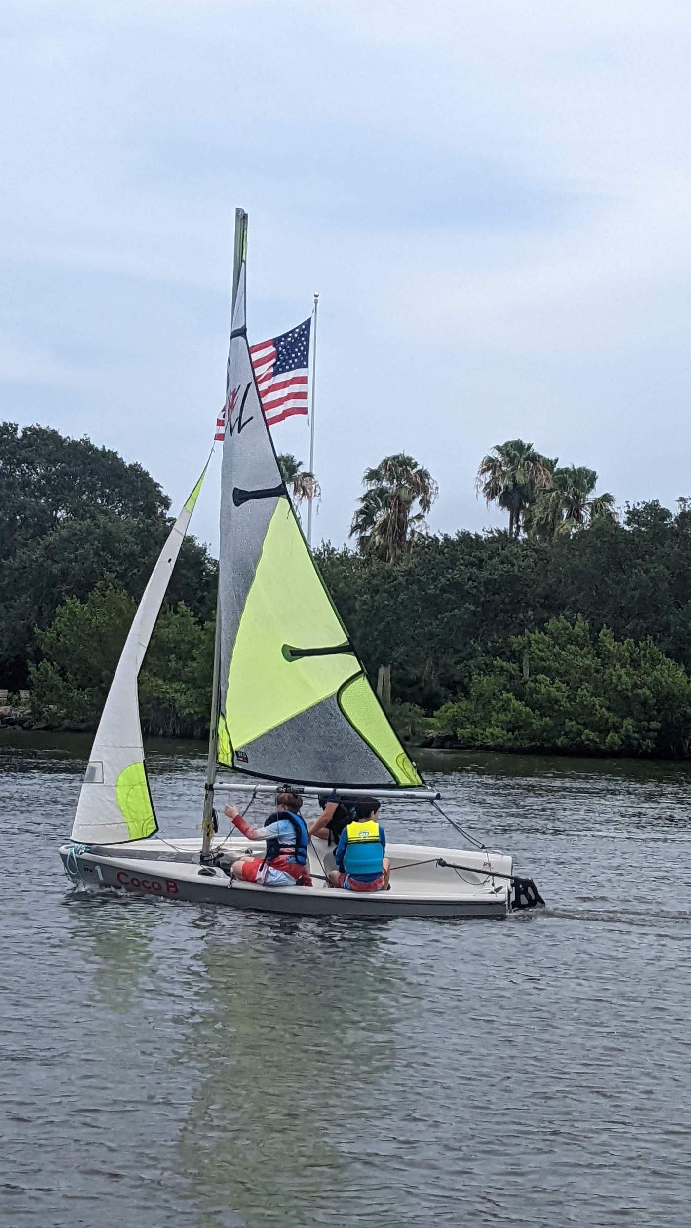 A sailboat sailing past an American flag