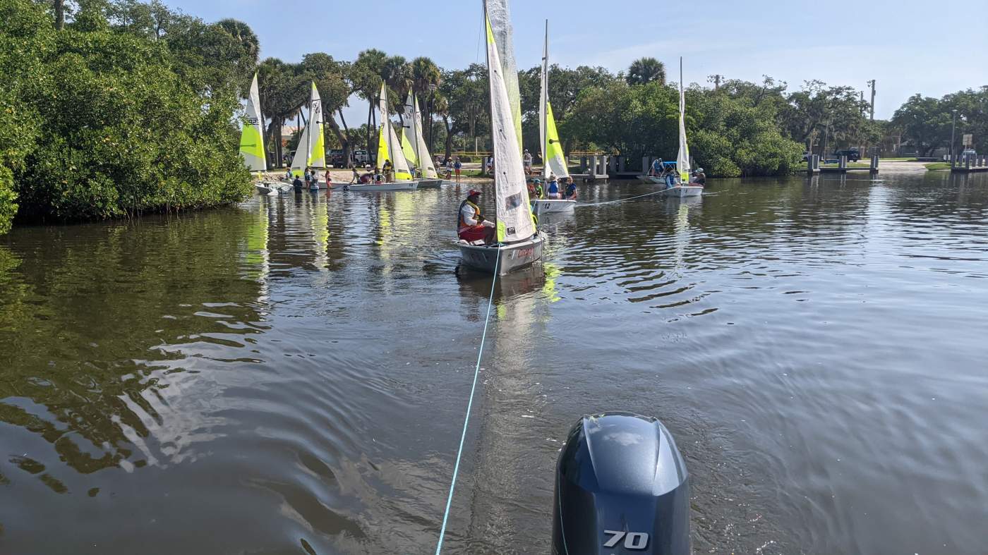 Three sailboats being towed