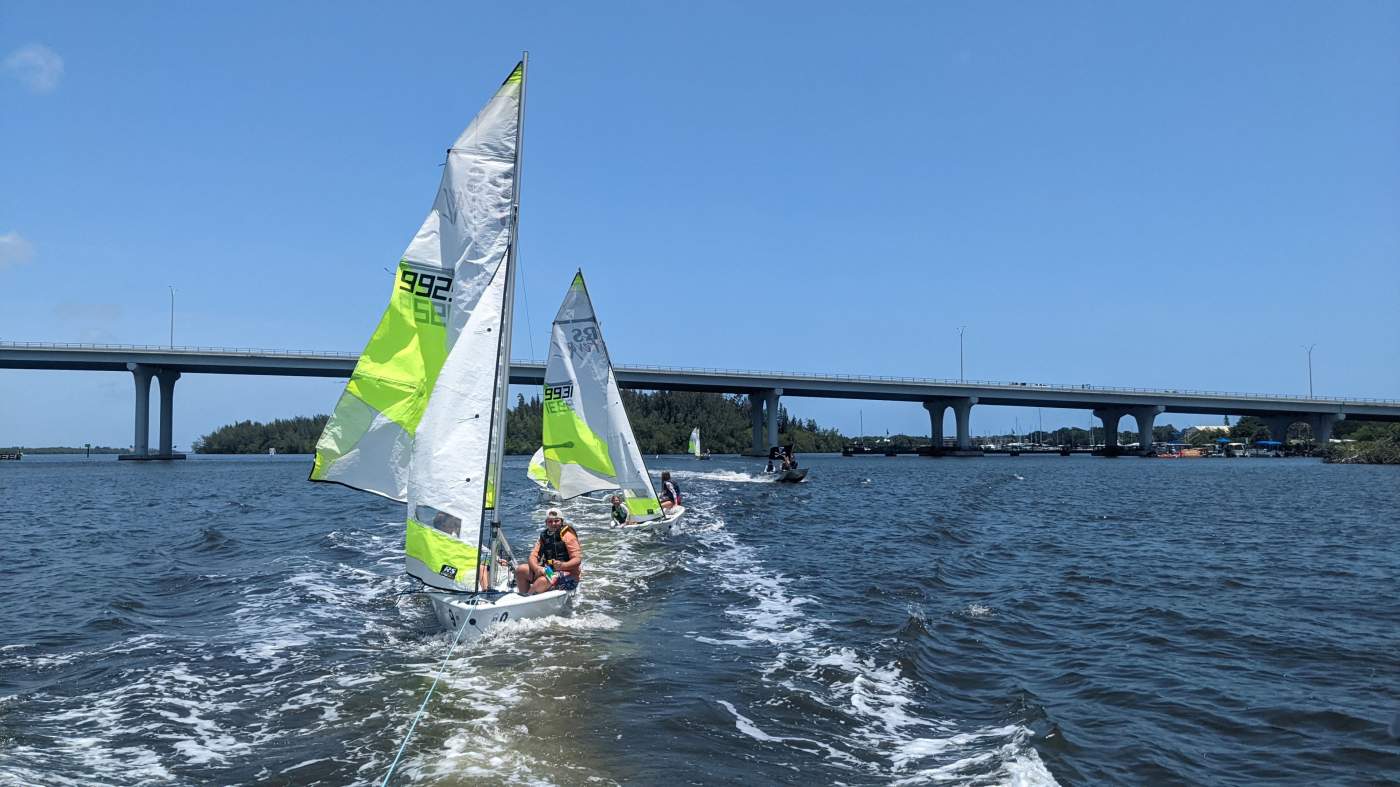 Three sailboats being towed