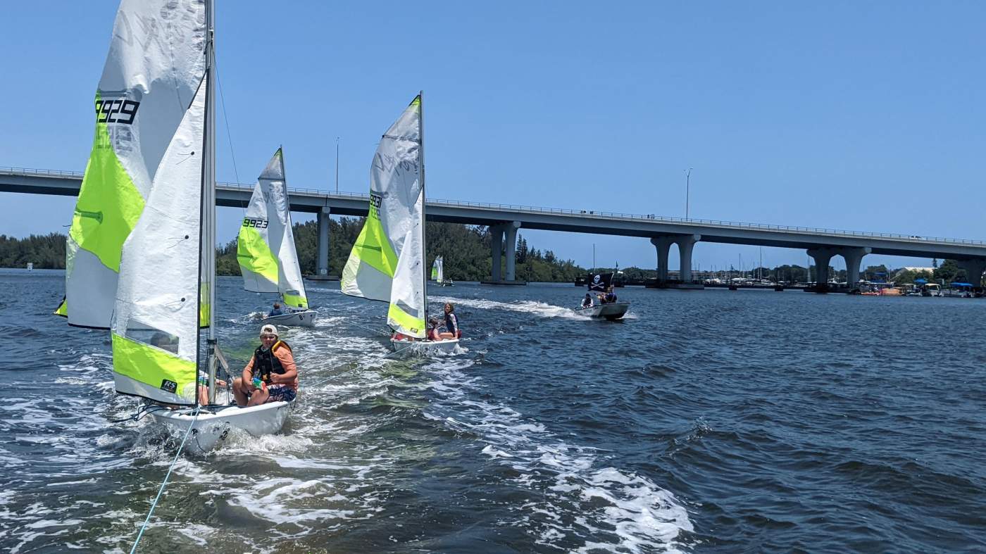 Three sailboats being towed