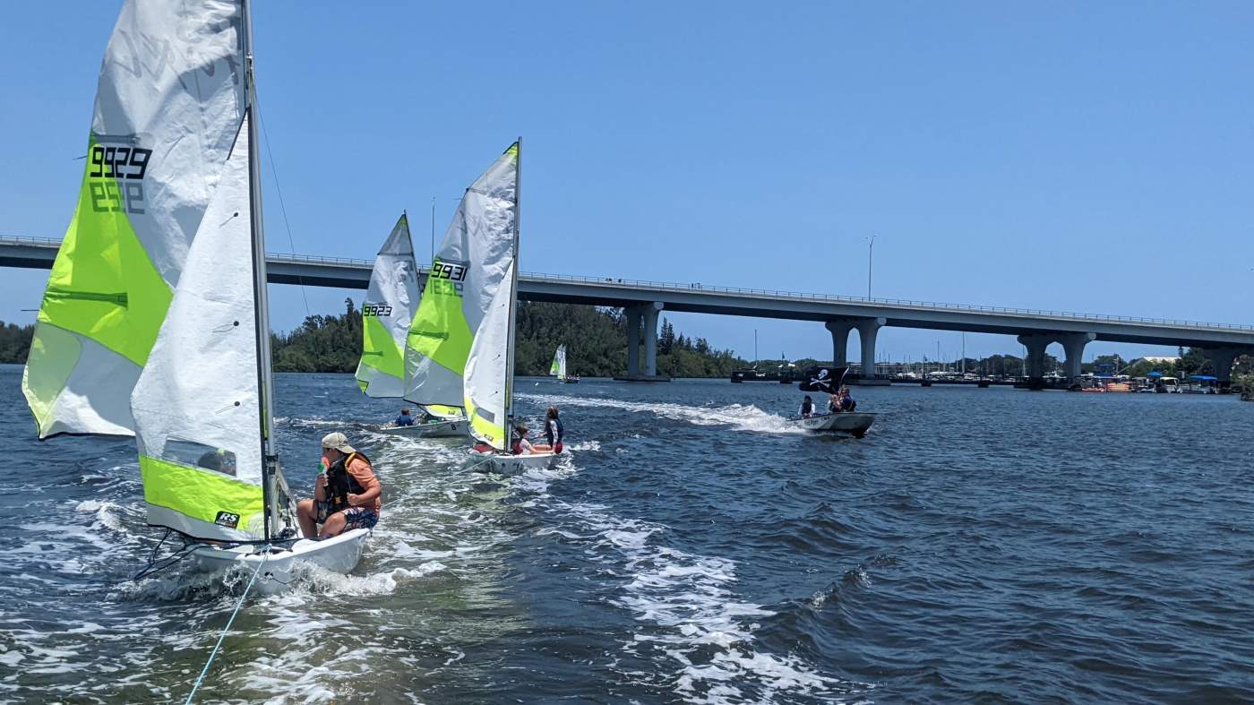 Three sailboats being towed