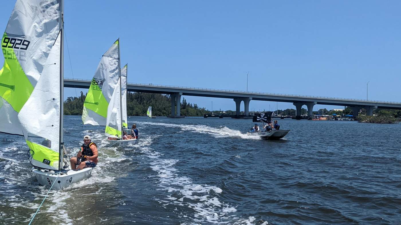 Three sailboats being towed