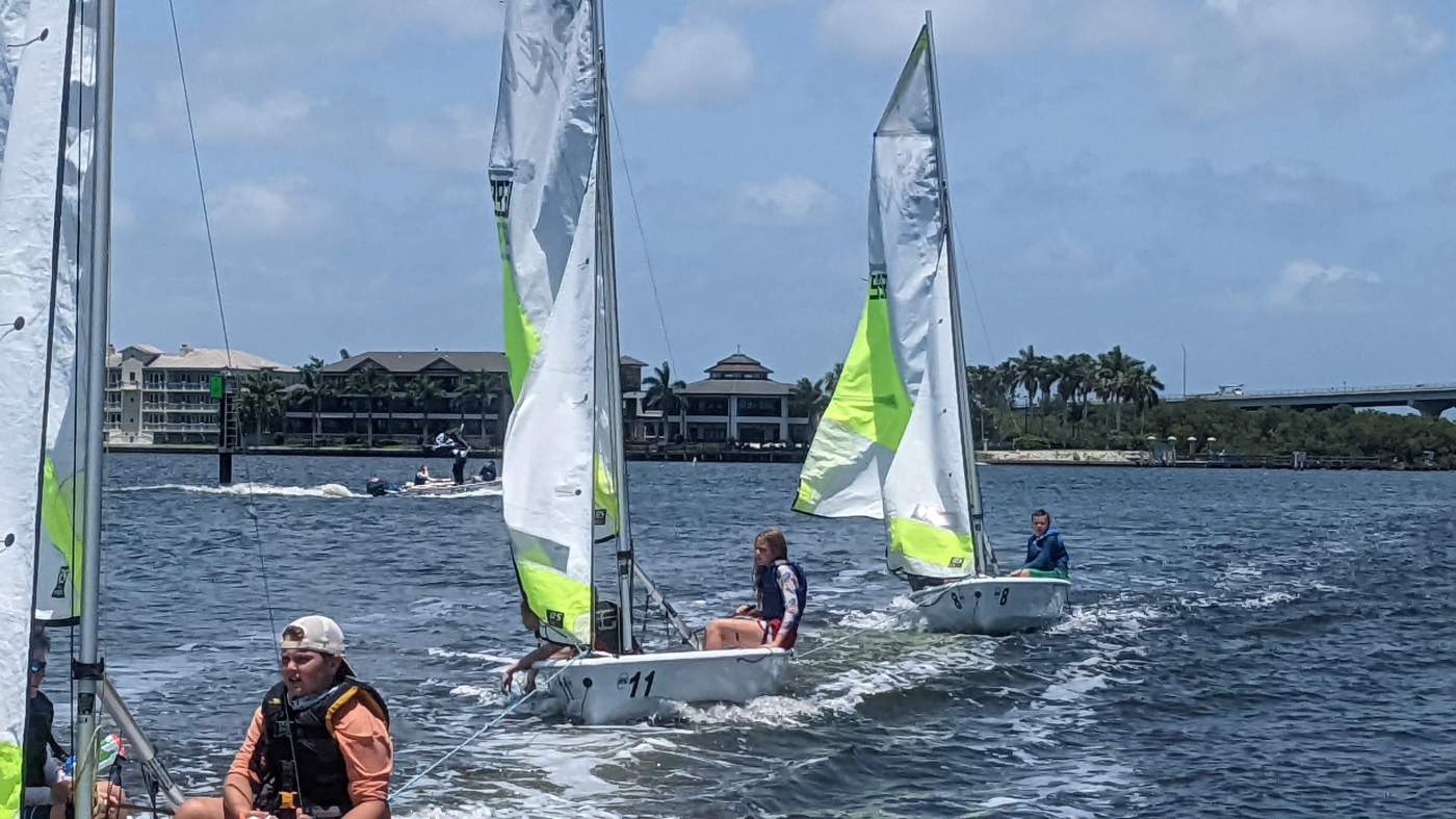 Three sailboats being towed