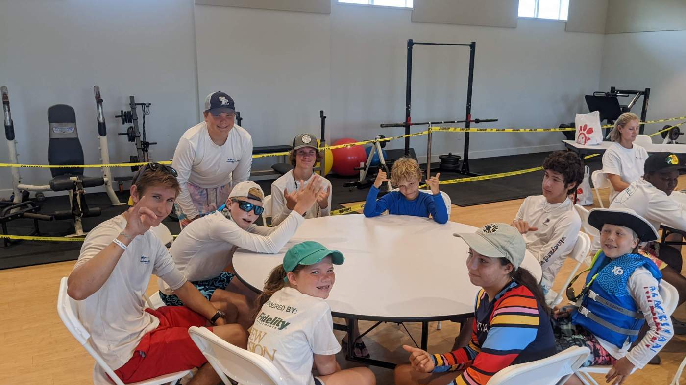 A group of children seated around several tables