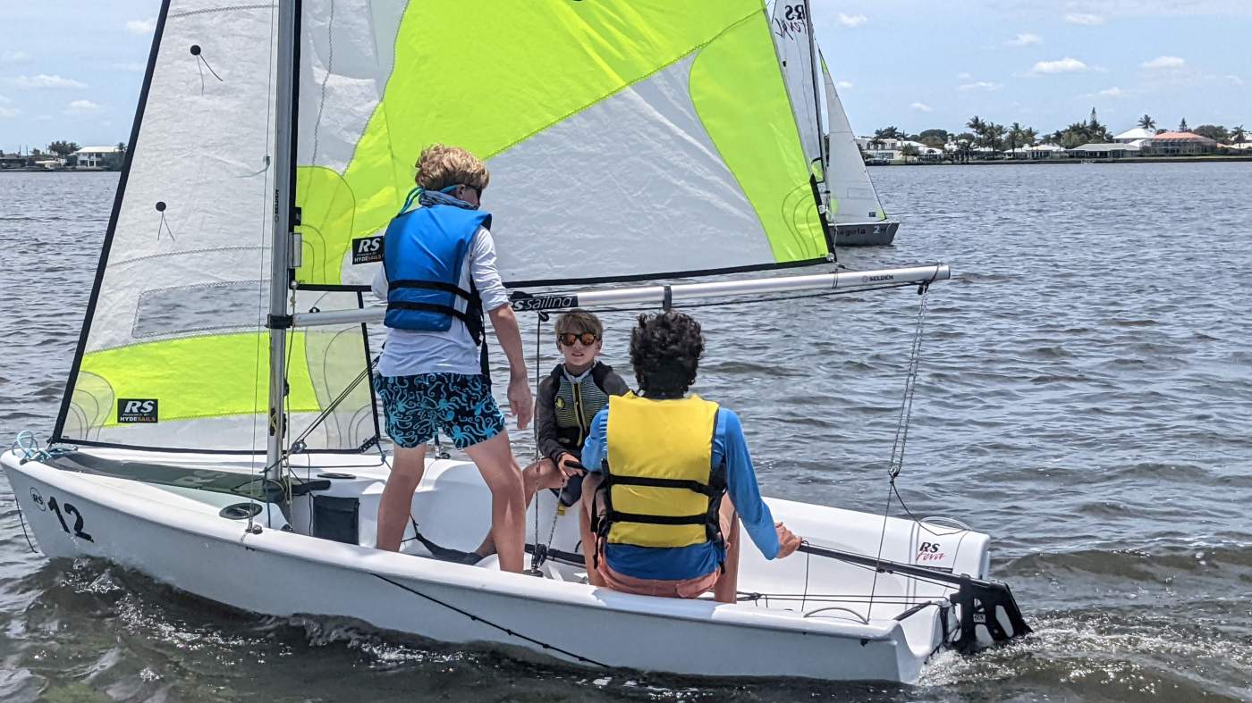 Three boys sailing a boat