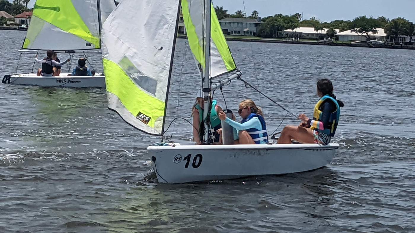 Three girls sailing a boat