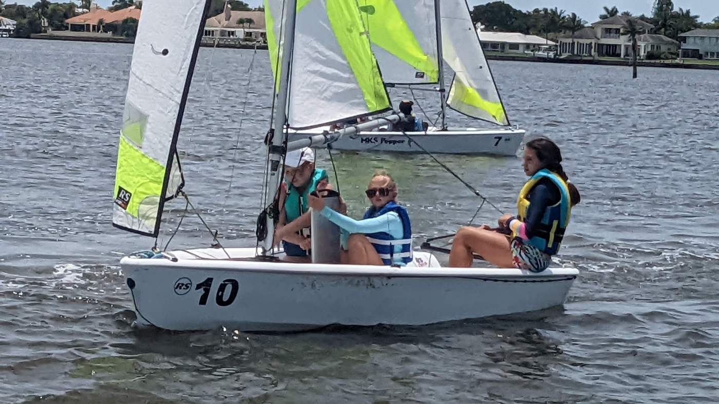 Three girls sailing a boat