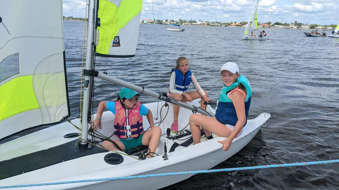 Three girls sailing a boat