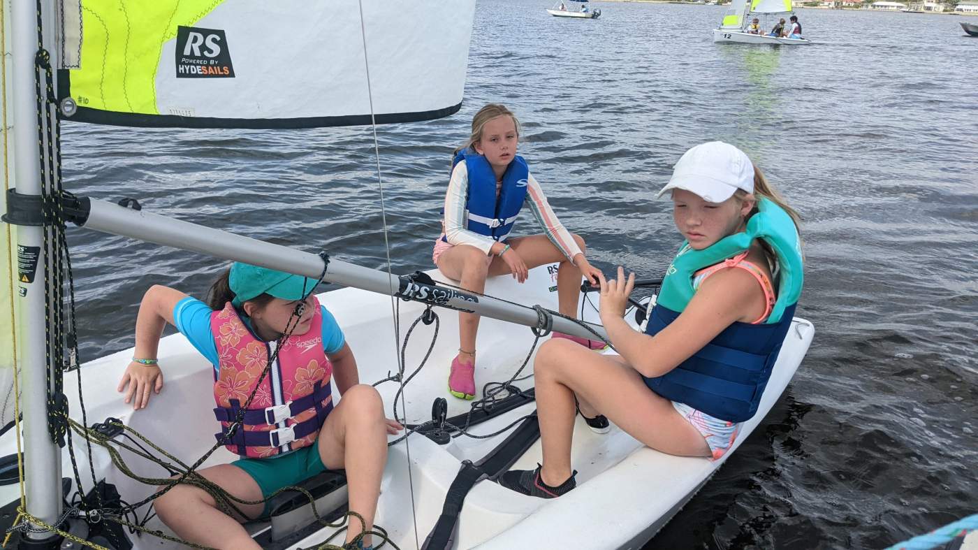 Three girls sailing a boat