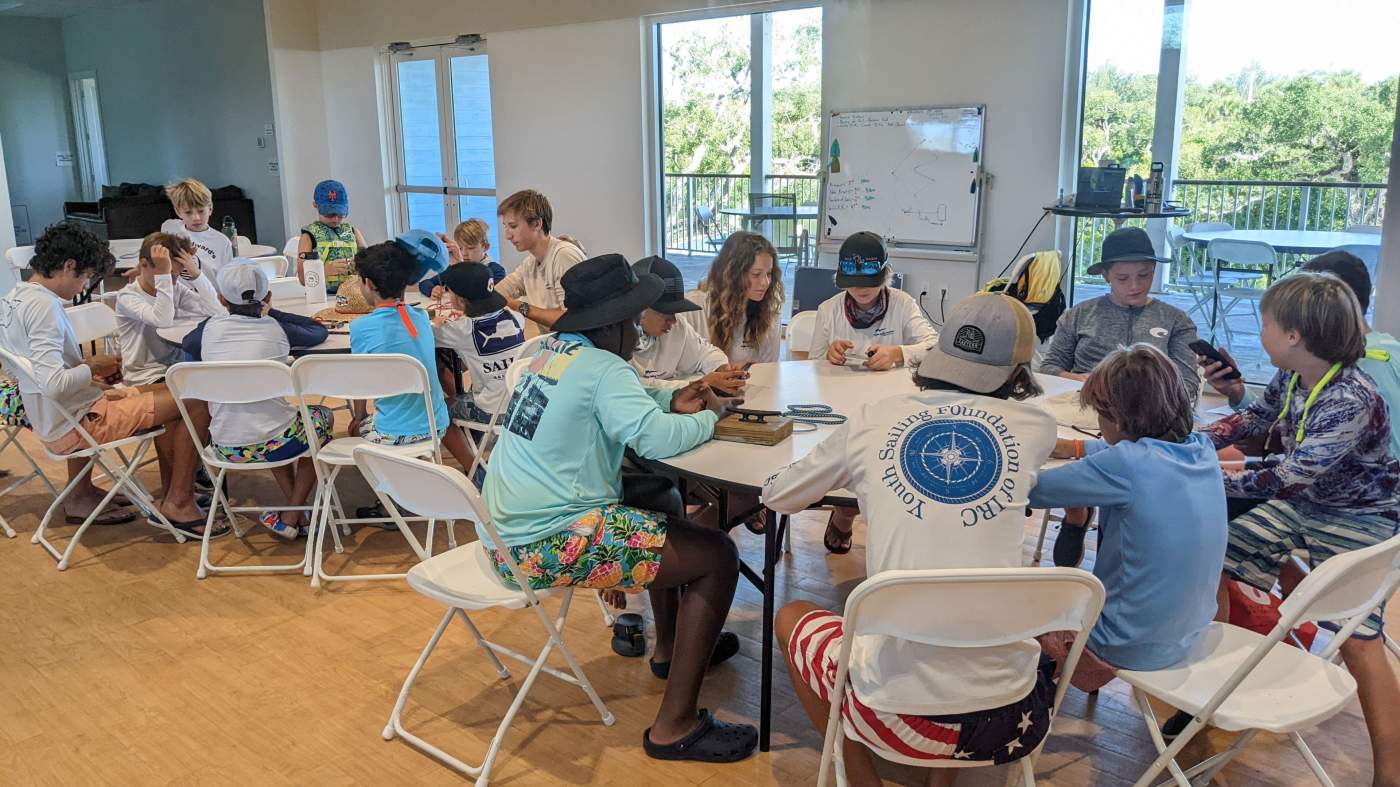 A group of children seated around several tables