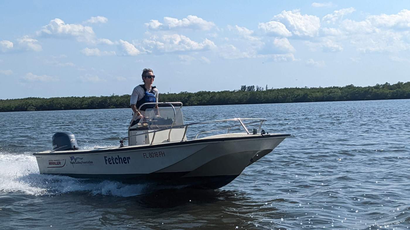 A person standing up in a traveling powerboat