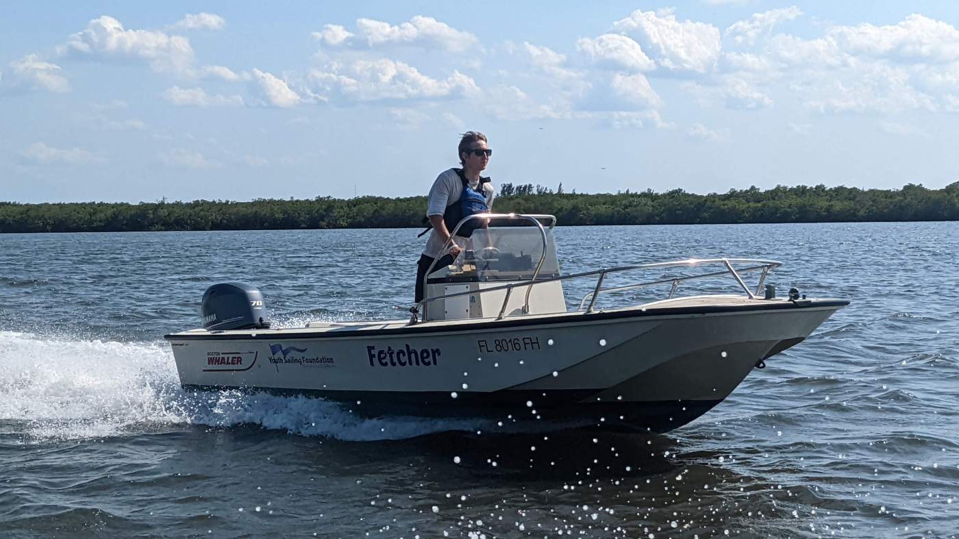 A person standing up in a traveling powerboat