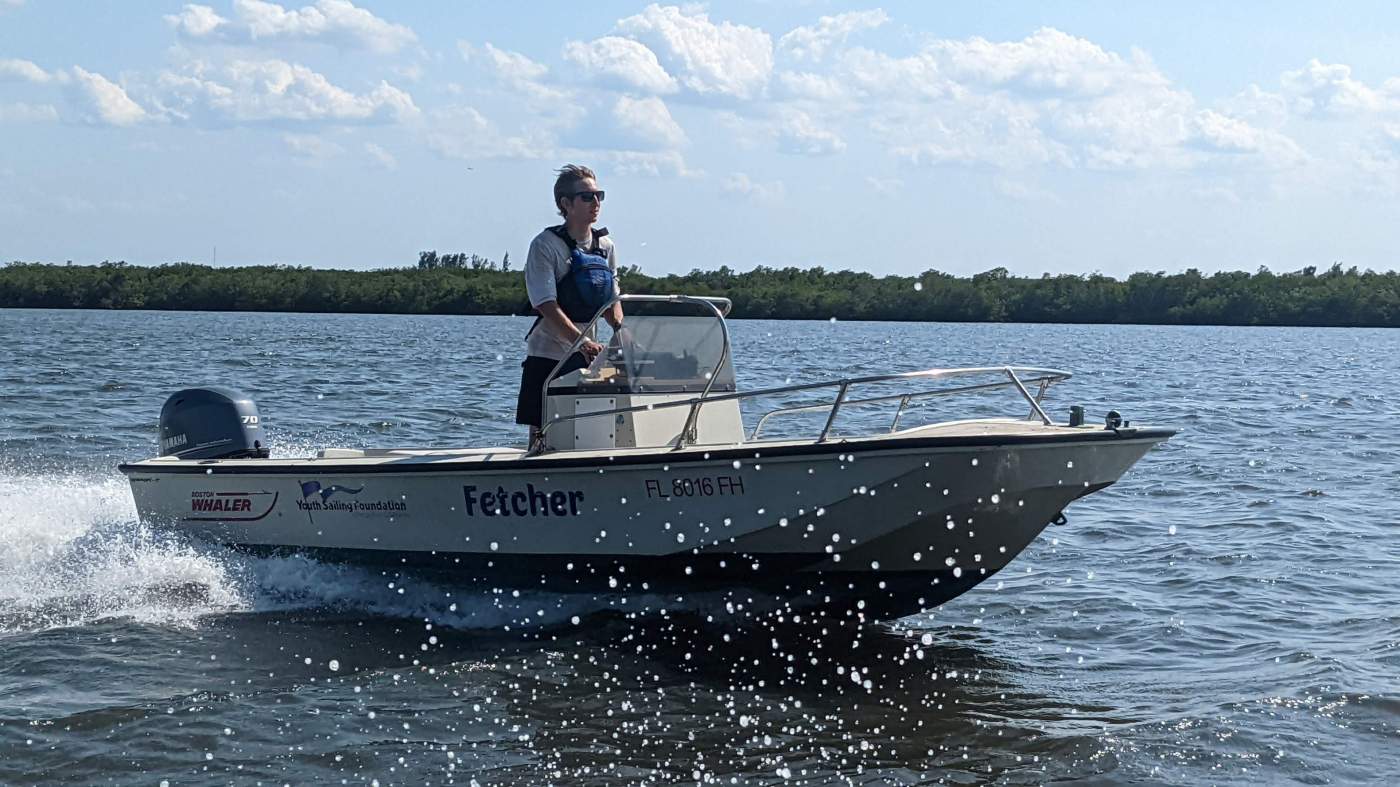 A person standing up in a traveling powerboat