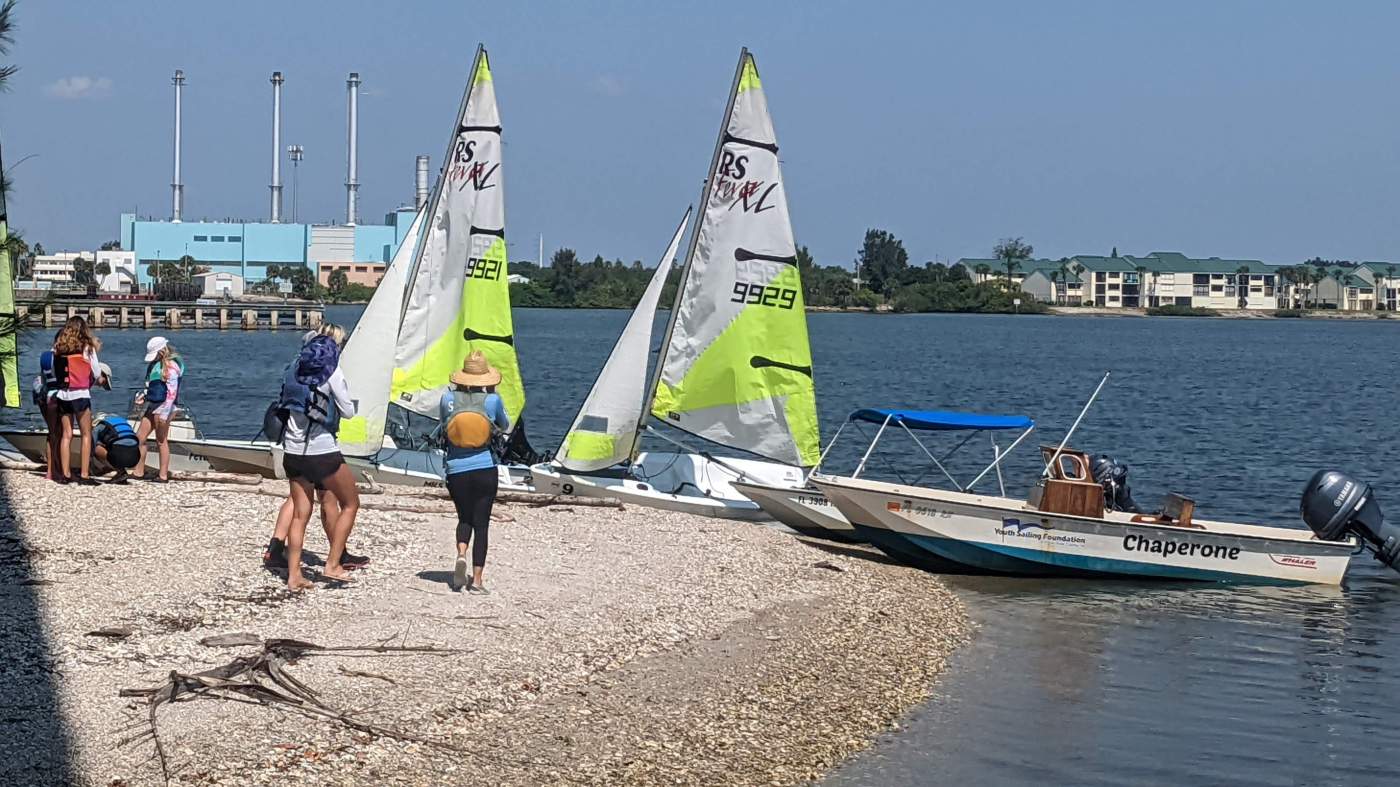 People and sailboats on the beach