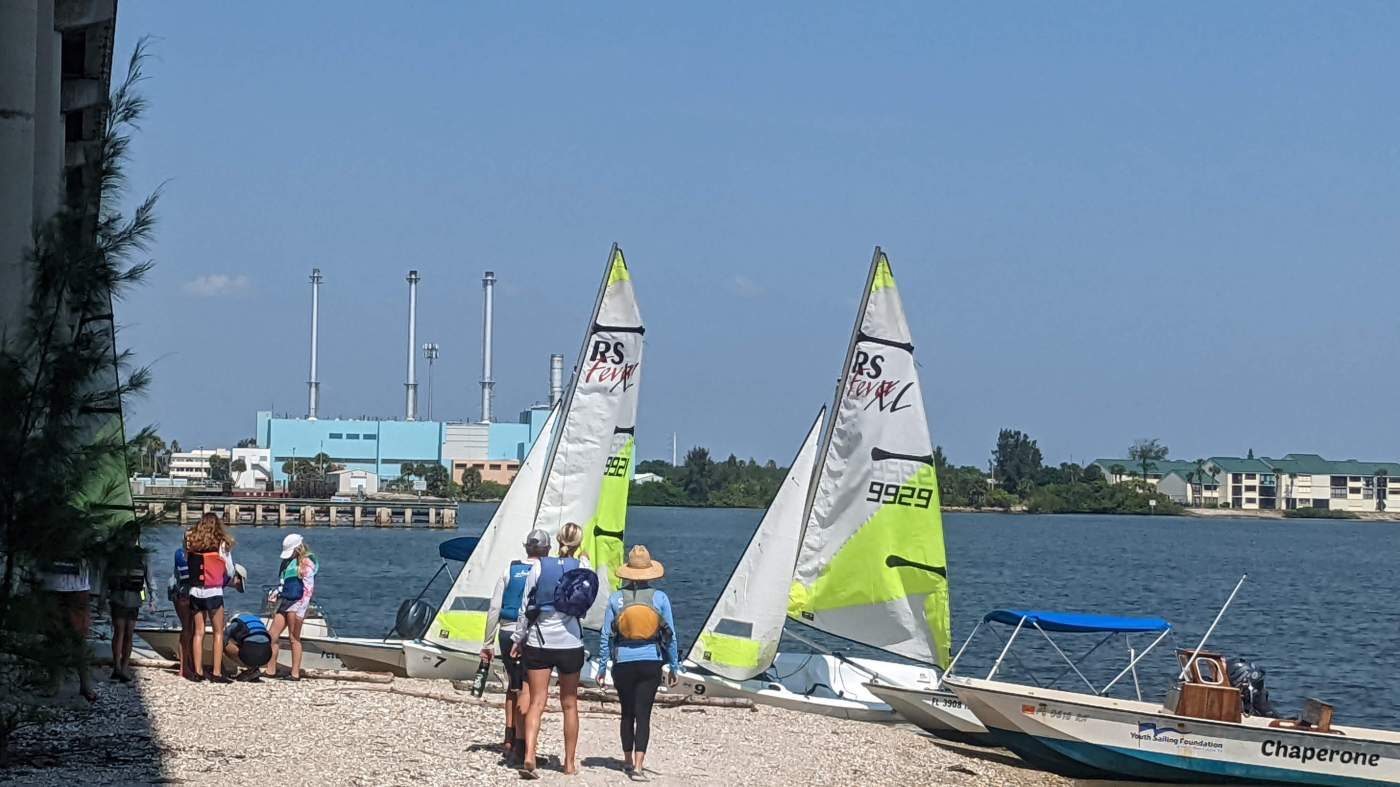People and sailboats on the beach