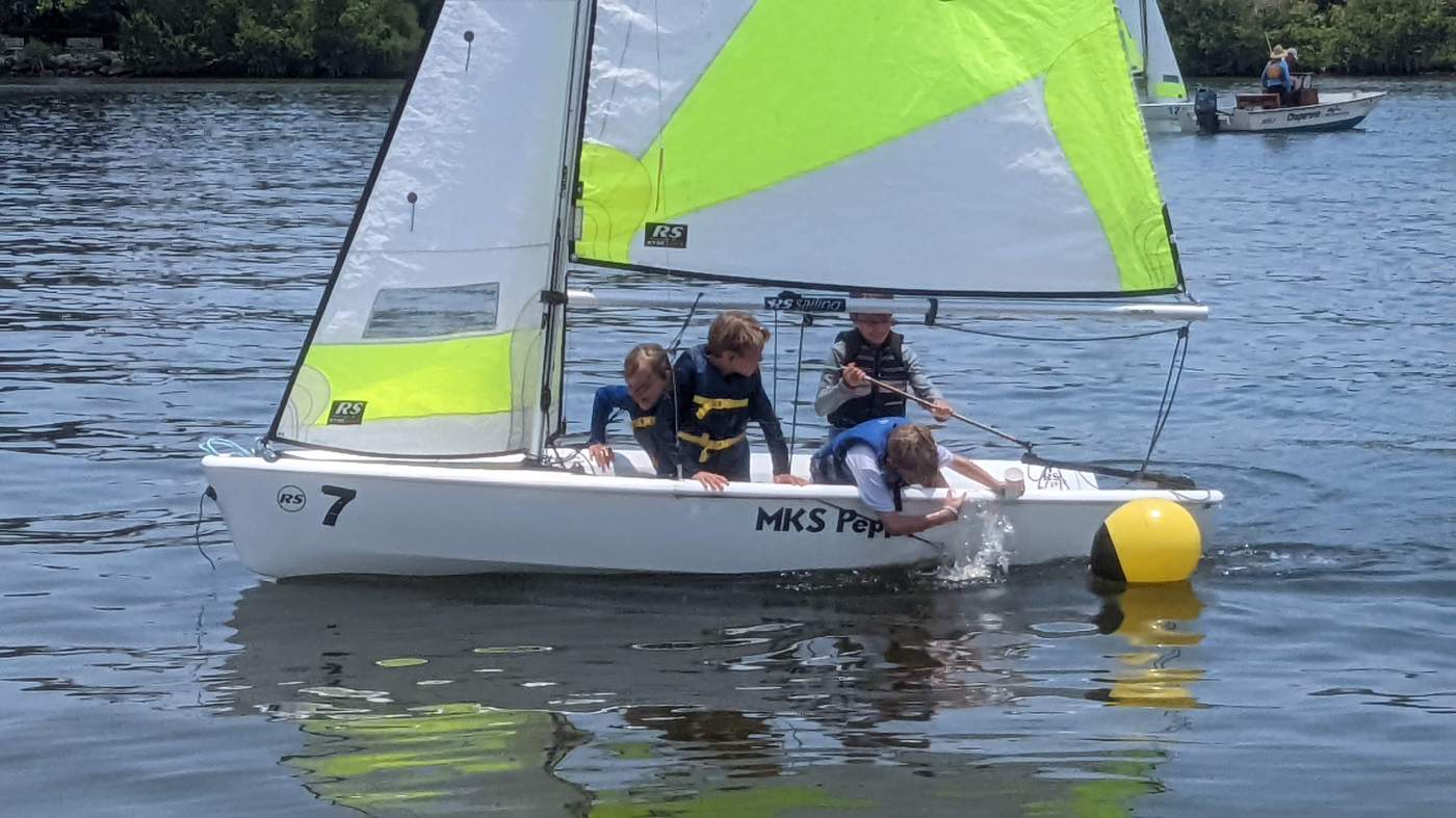 Four boys sailing a boat