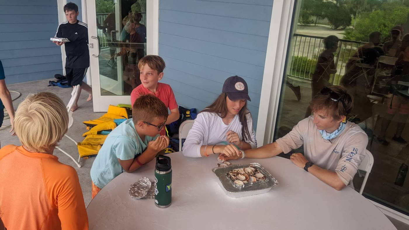 A group of children seated around several tables, having a snack