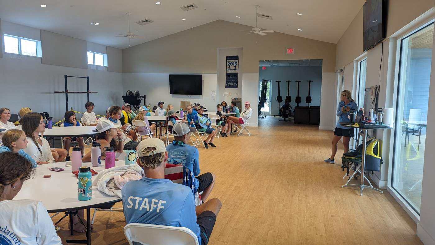 Children seated around a table listening to their instructor