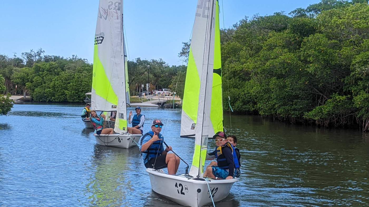 Three sailboats being towed