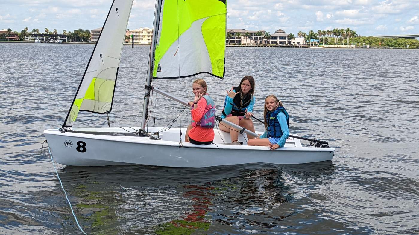 Three girls sailing a boat