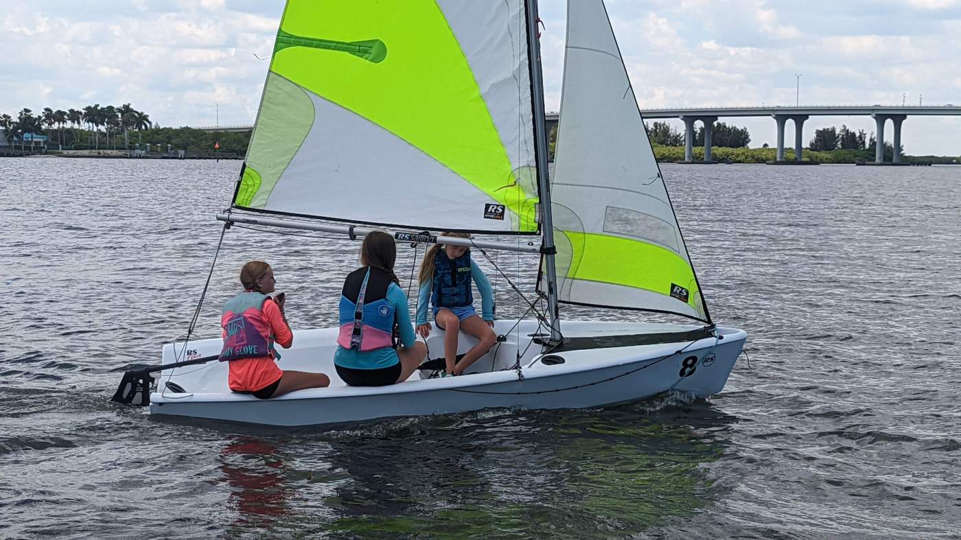 Three girls sailing a boat