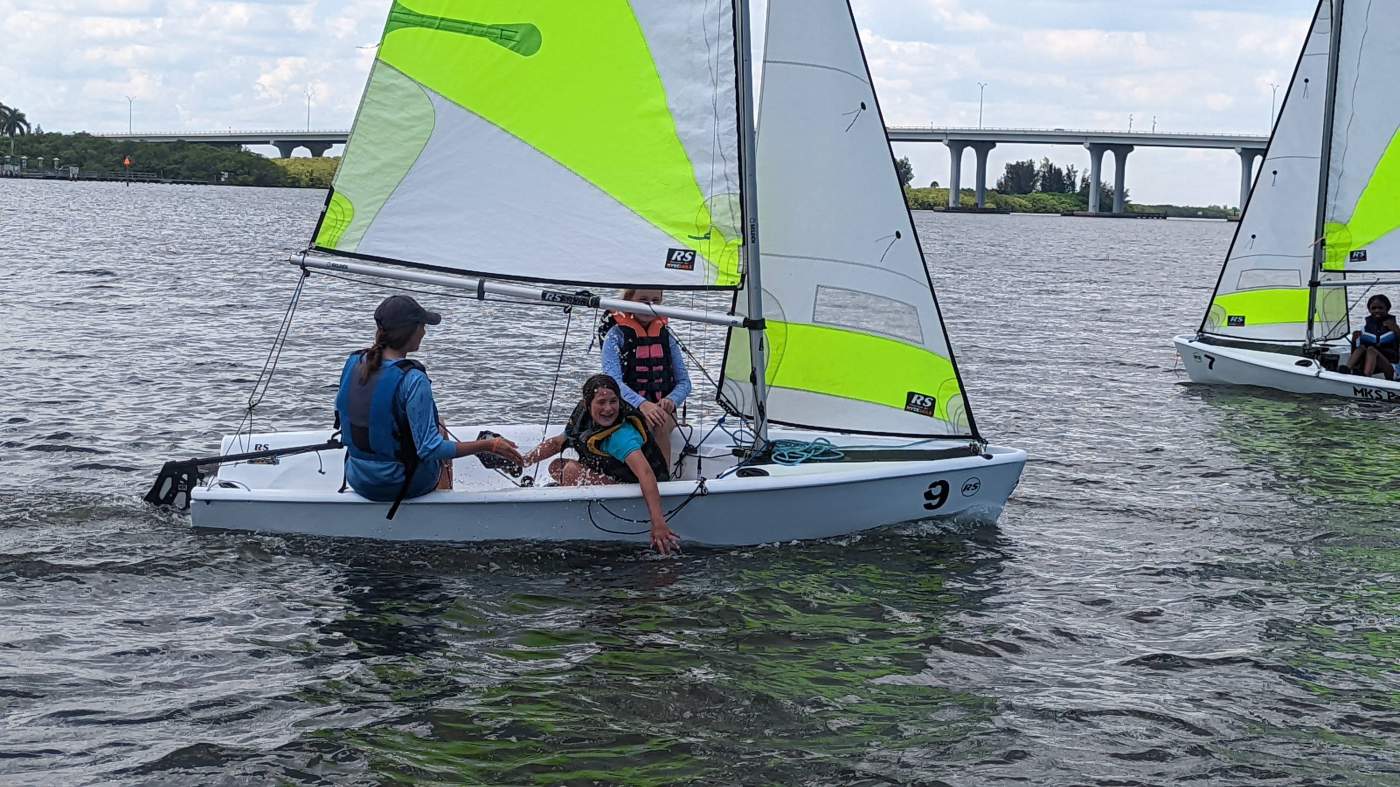 Three girls sailing a boat