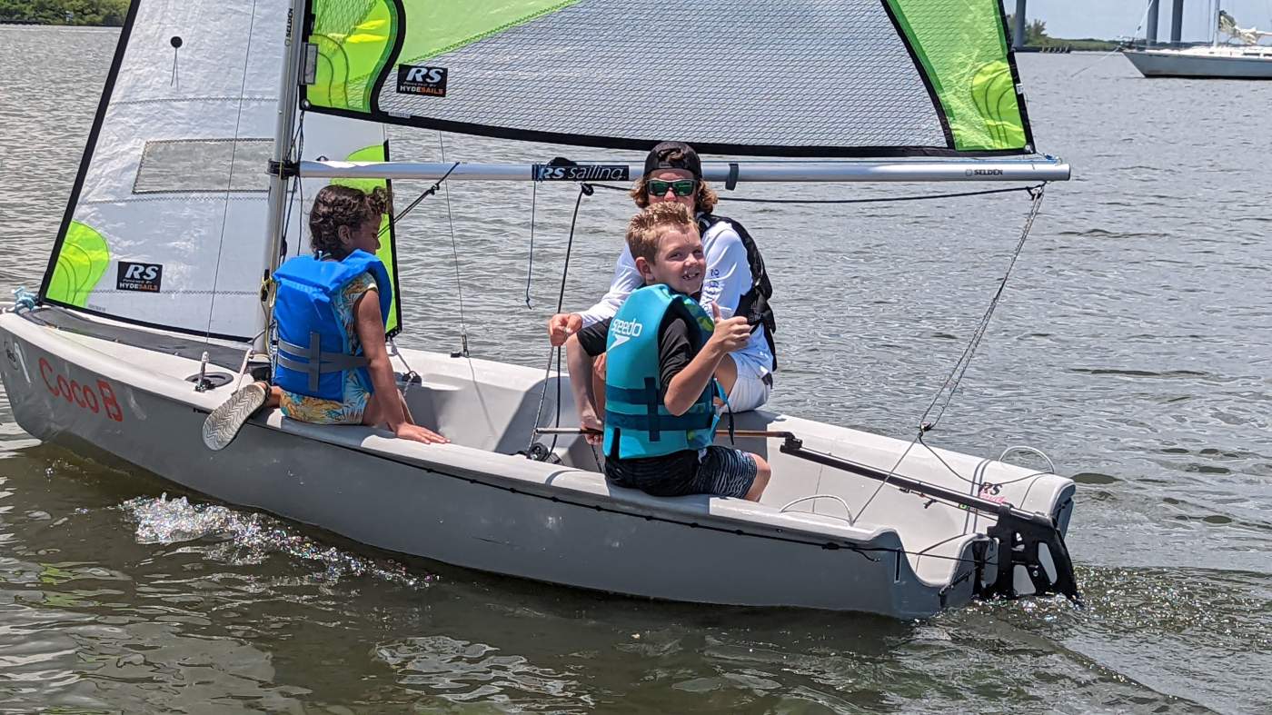 Three boys sailing a boat