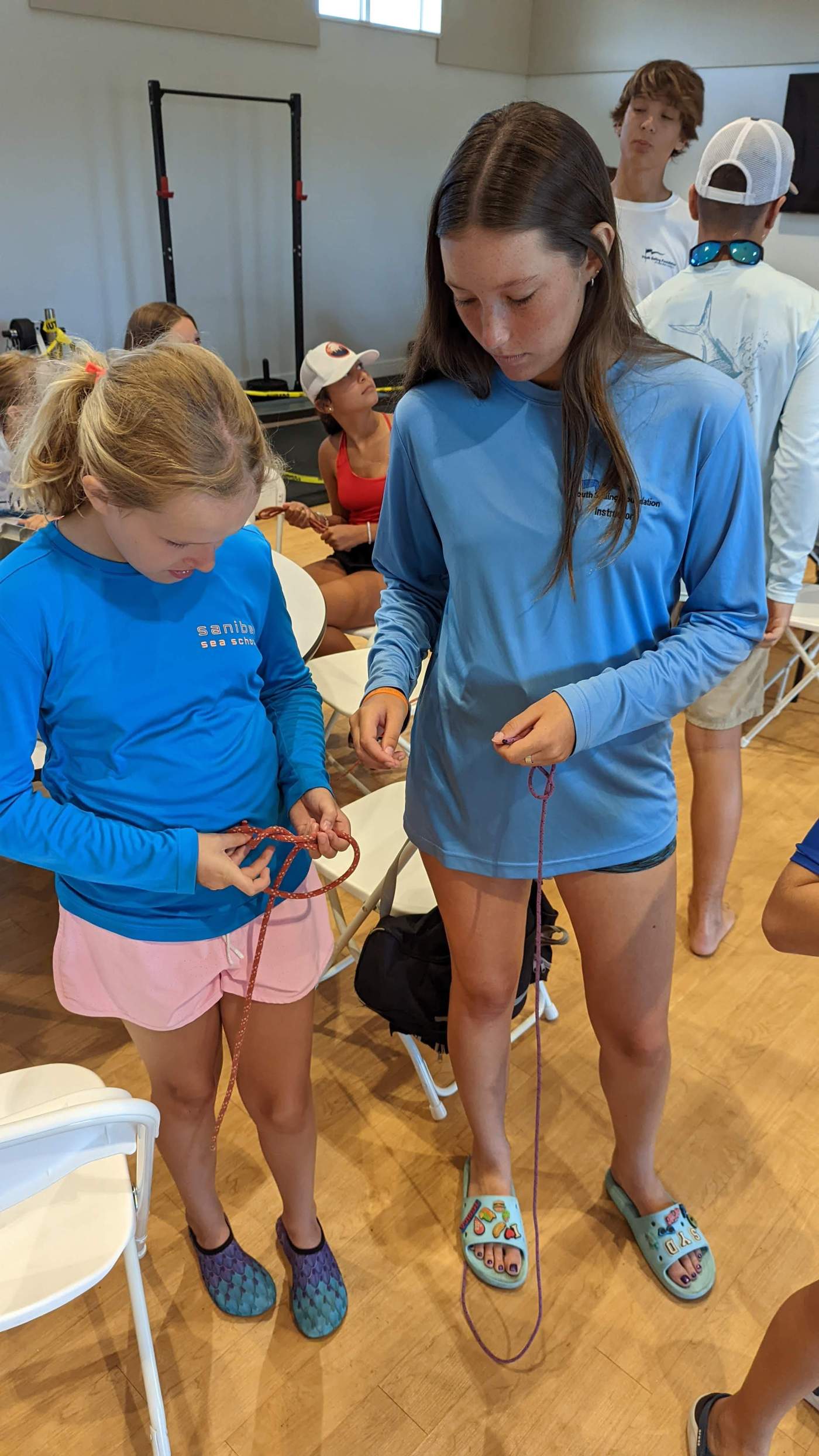 Several young ladies practicing knot tying