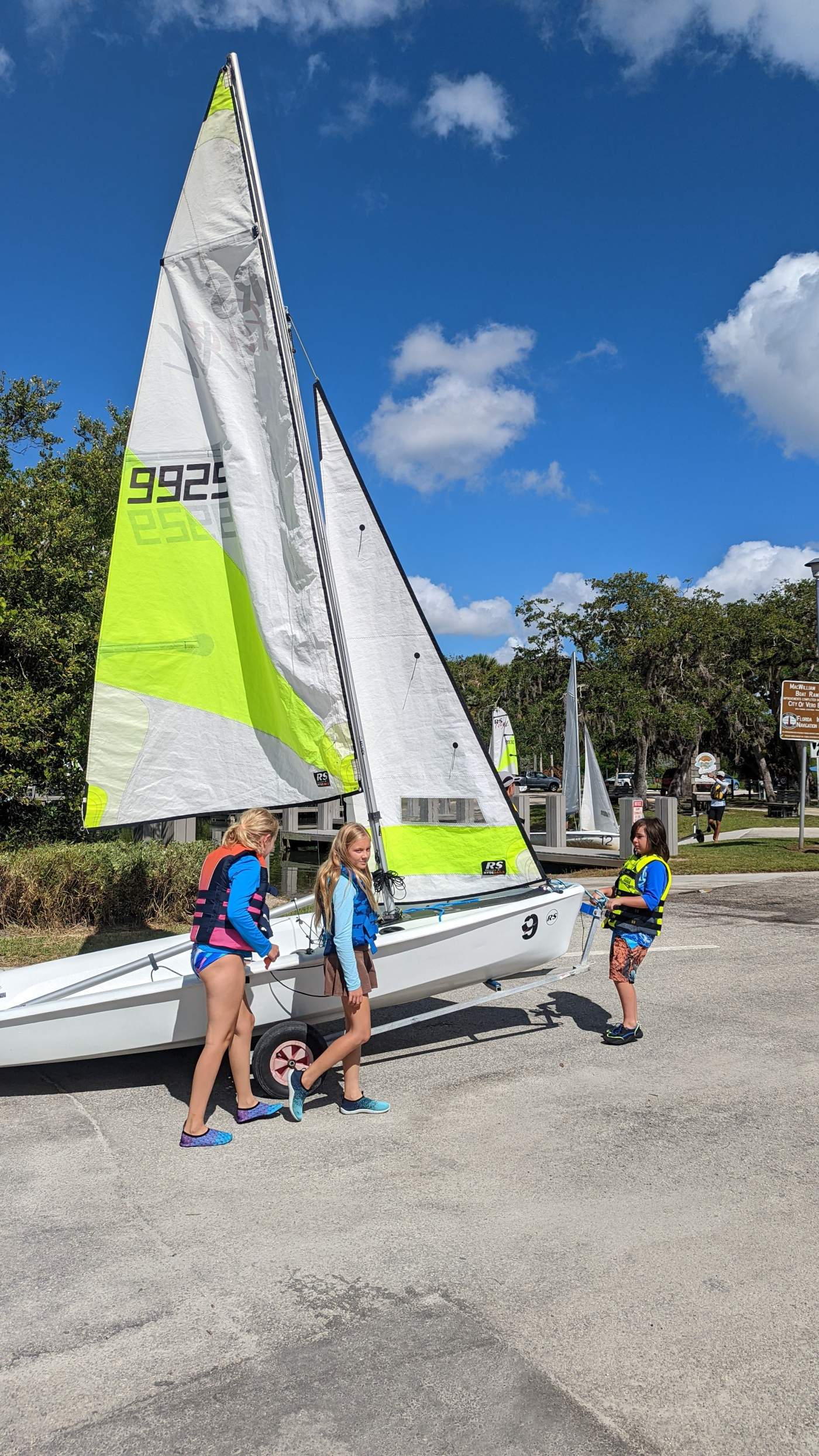 Three girls launching a sailboat