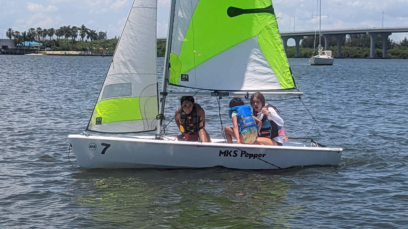 Three girls sailing a boat