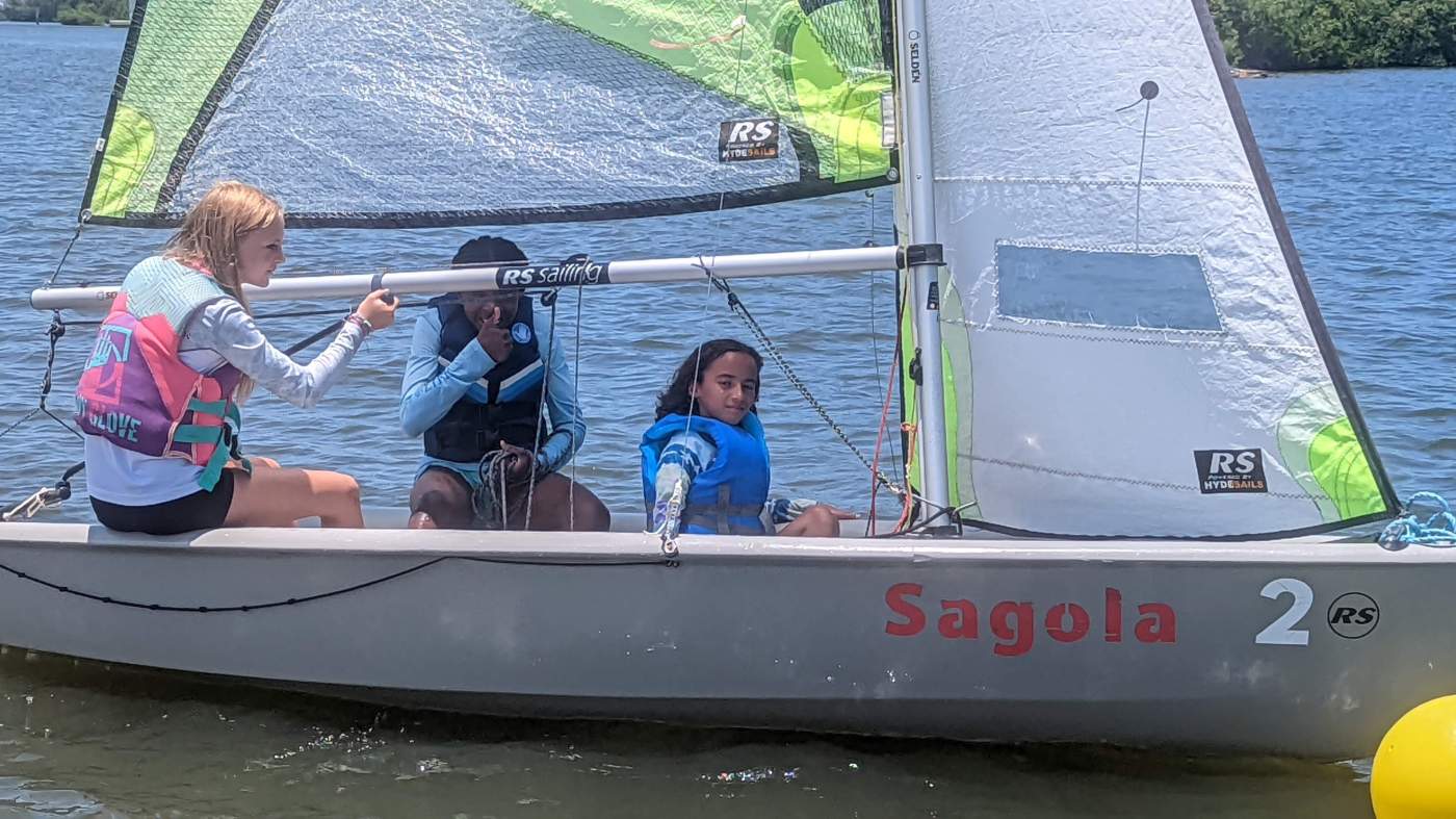 Three girls sailing a boat