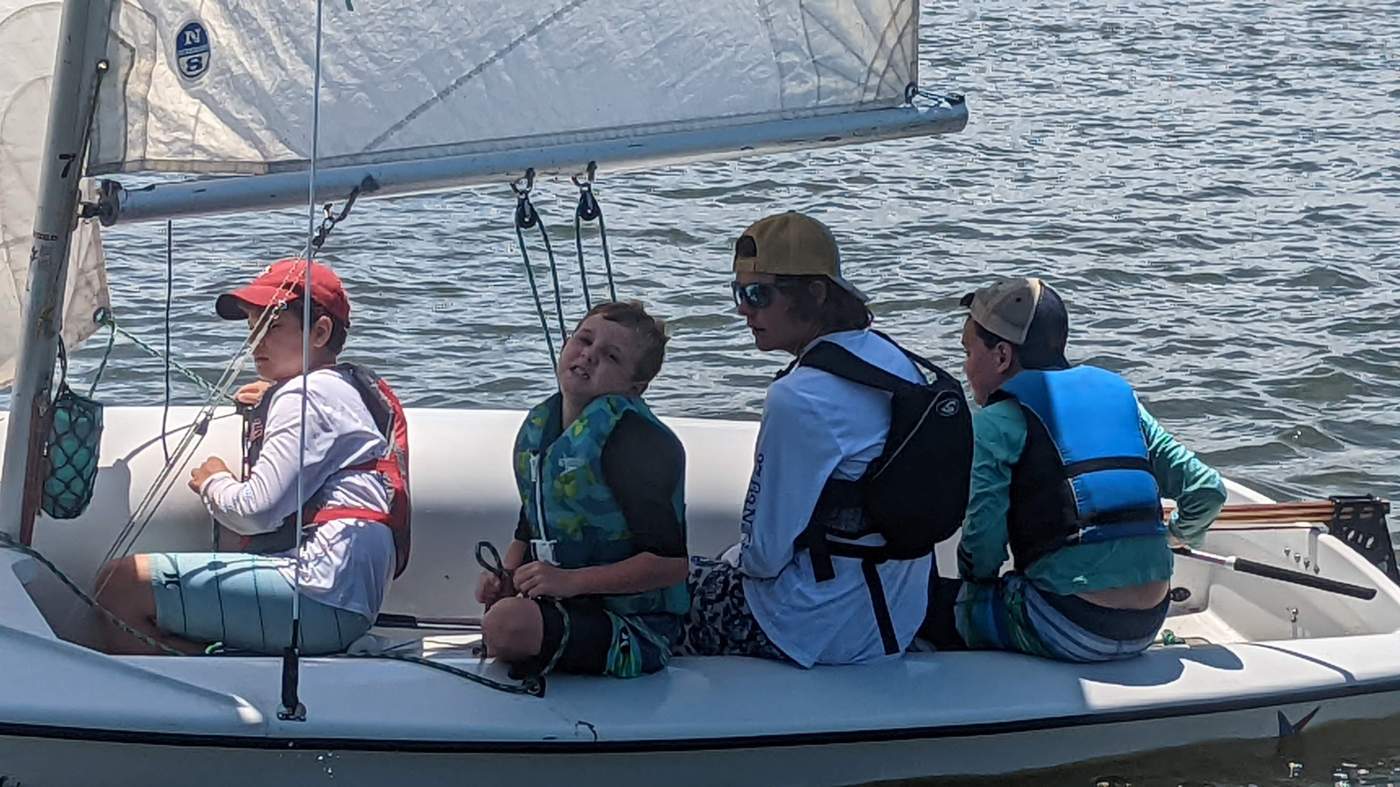 Four boys sailing a boat