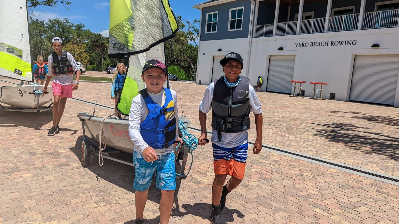 Several boys pulling sailboats