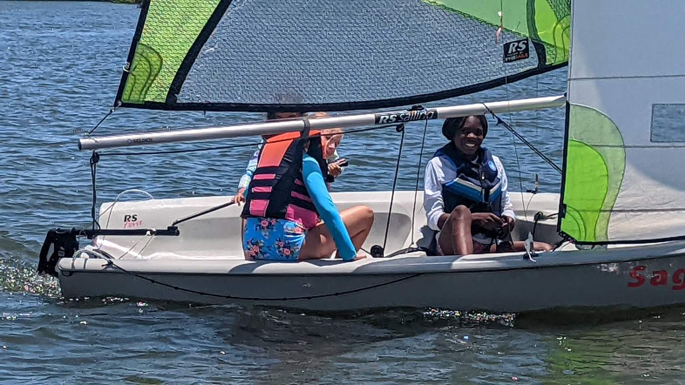 Three girls sailing a boat