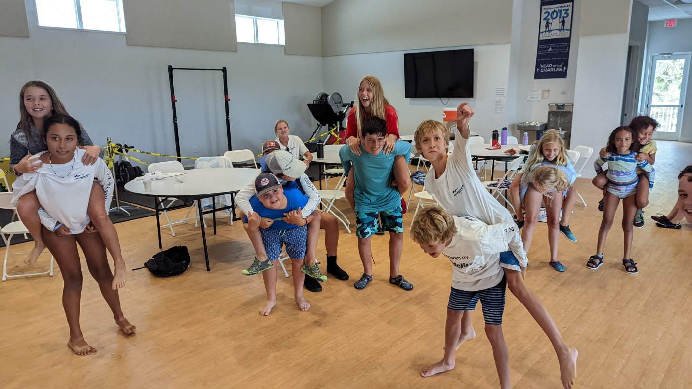 A group of children carrying other children piggyback