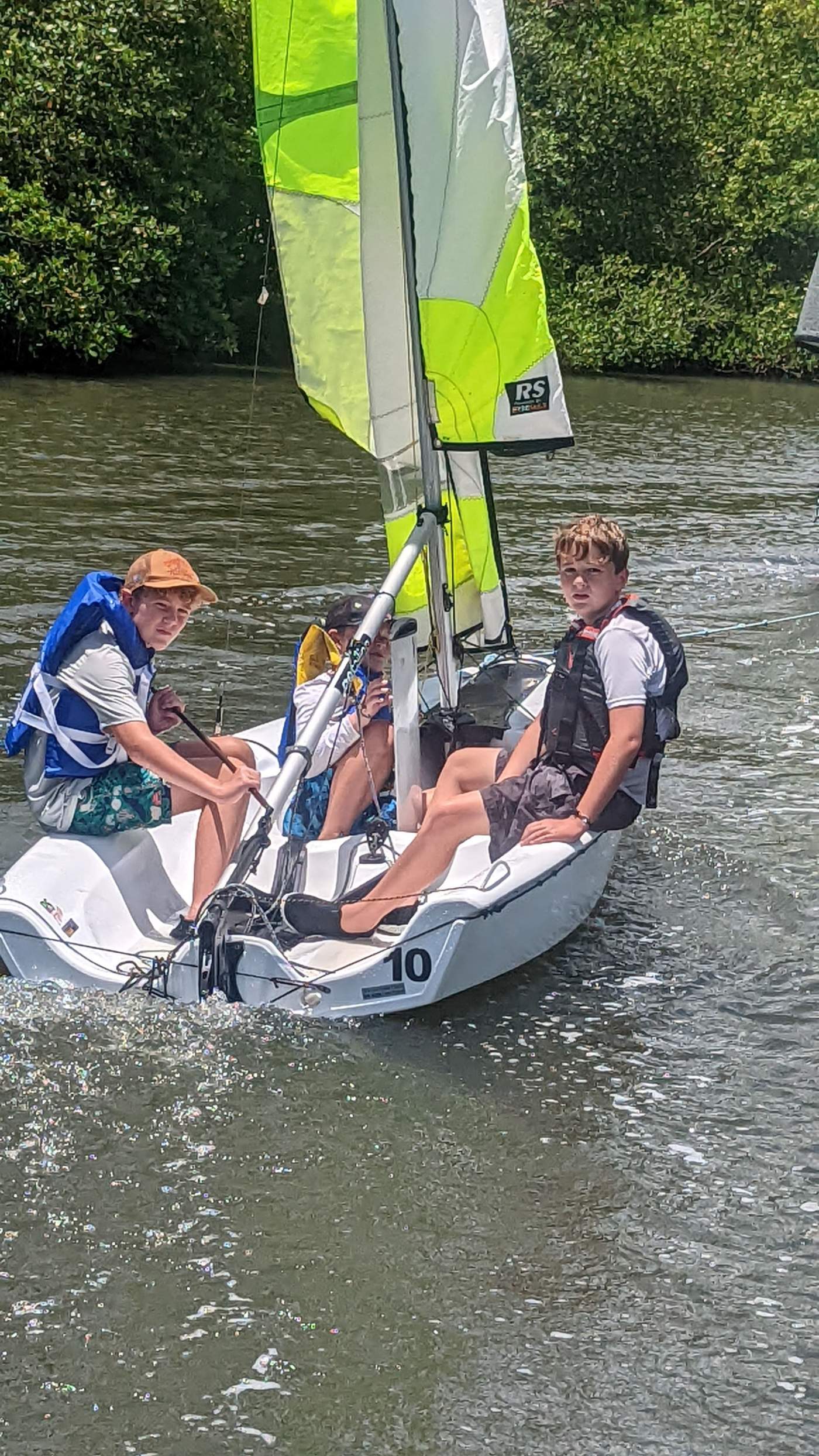 Three boys sailing a boat