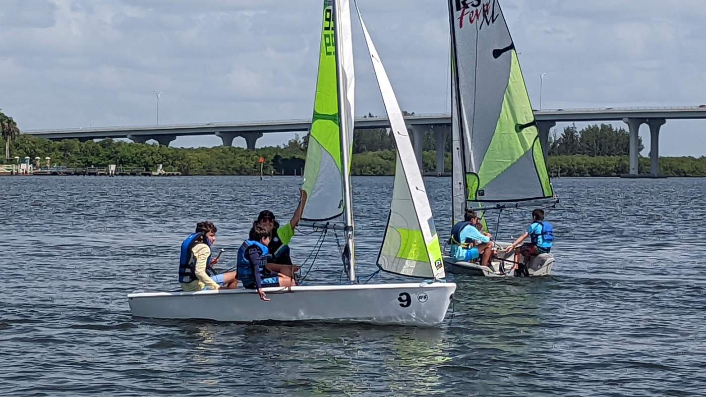 Two sailboats on the lagoon with a bridge in the background