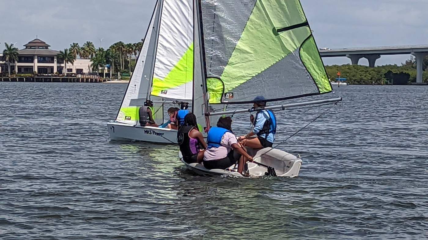 Two sailboats on the lagoon with a bridge in the background