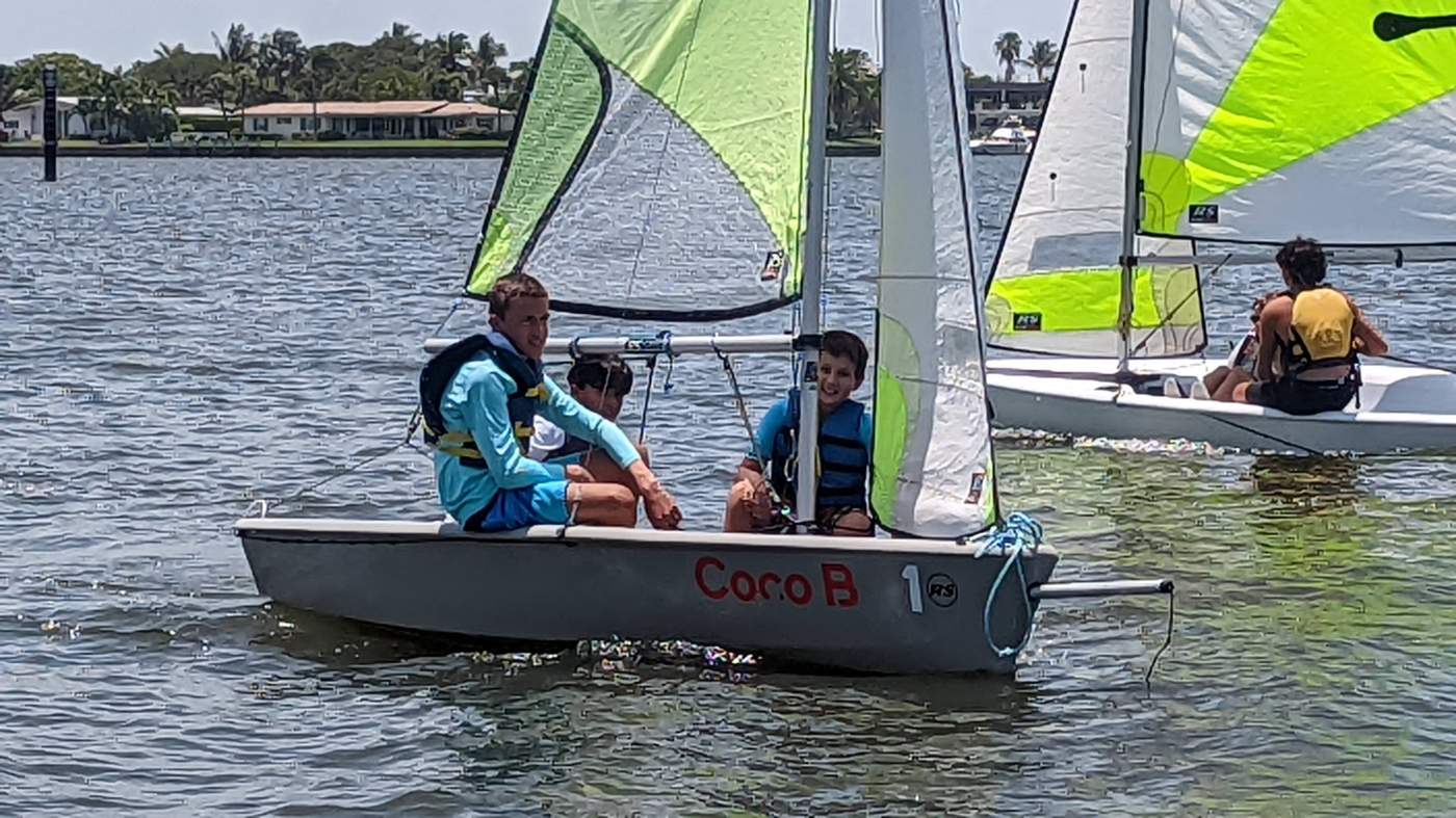 Three boys sailing a boat