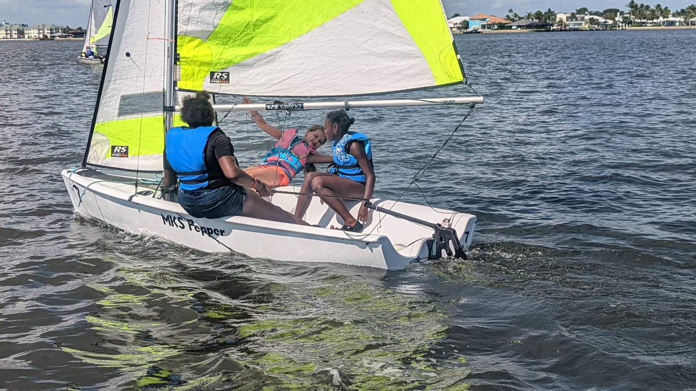 Three girls sailing a boat