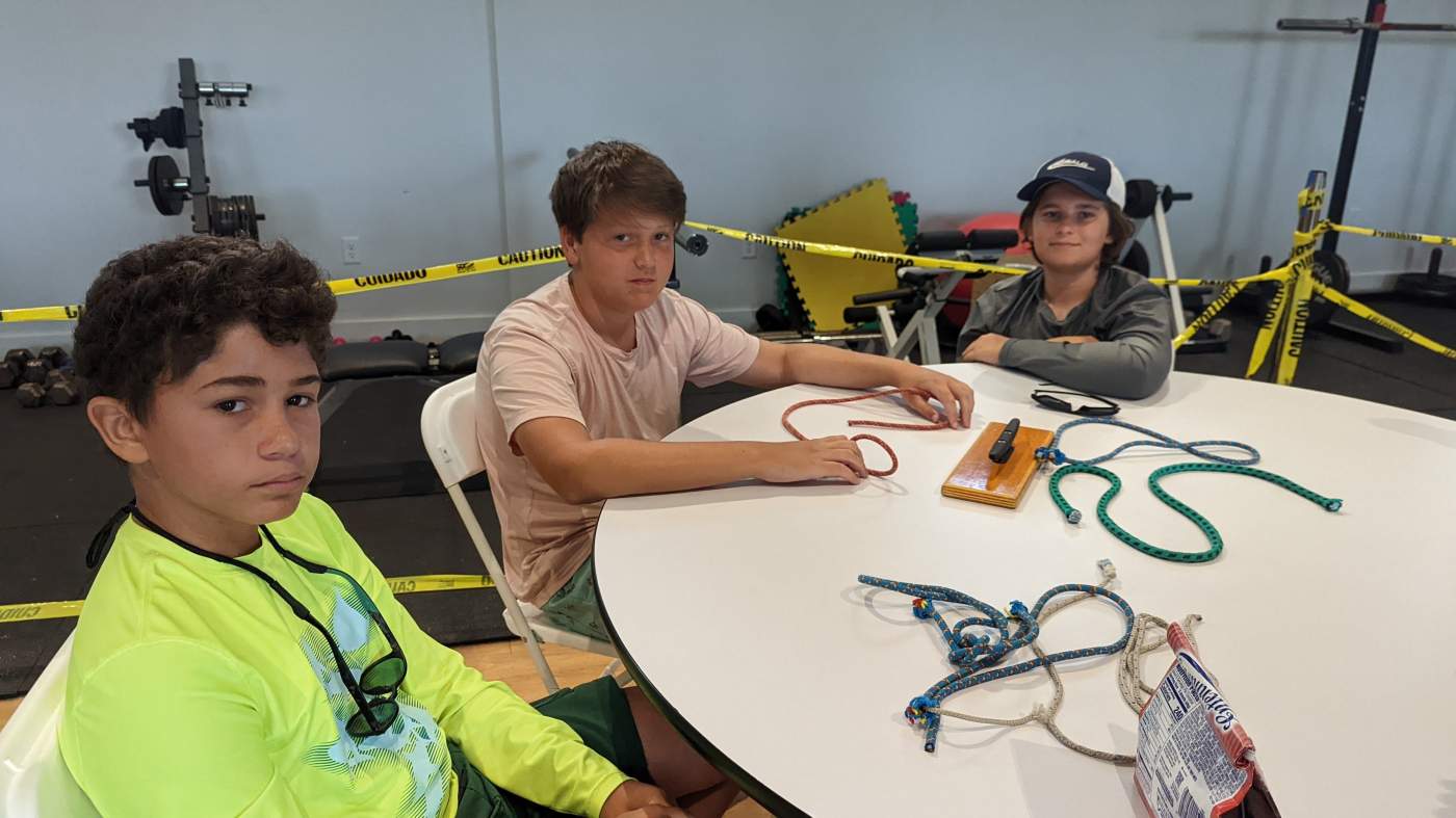 Several young men practicing knot tying