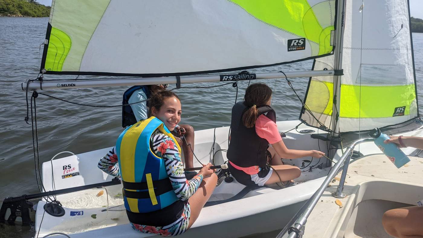 Three girls sailing a boat