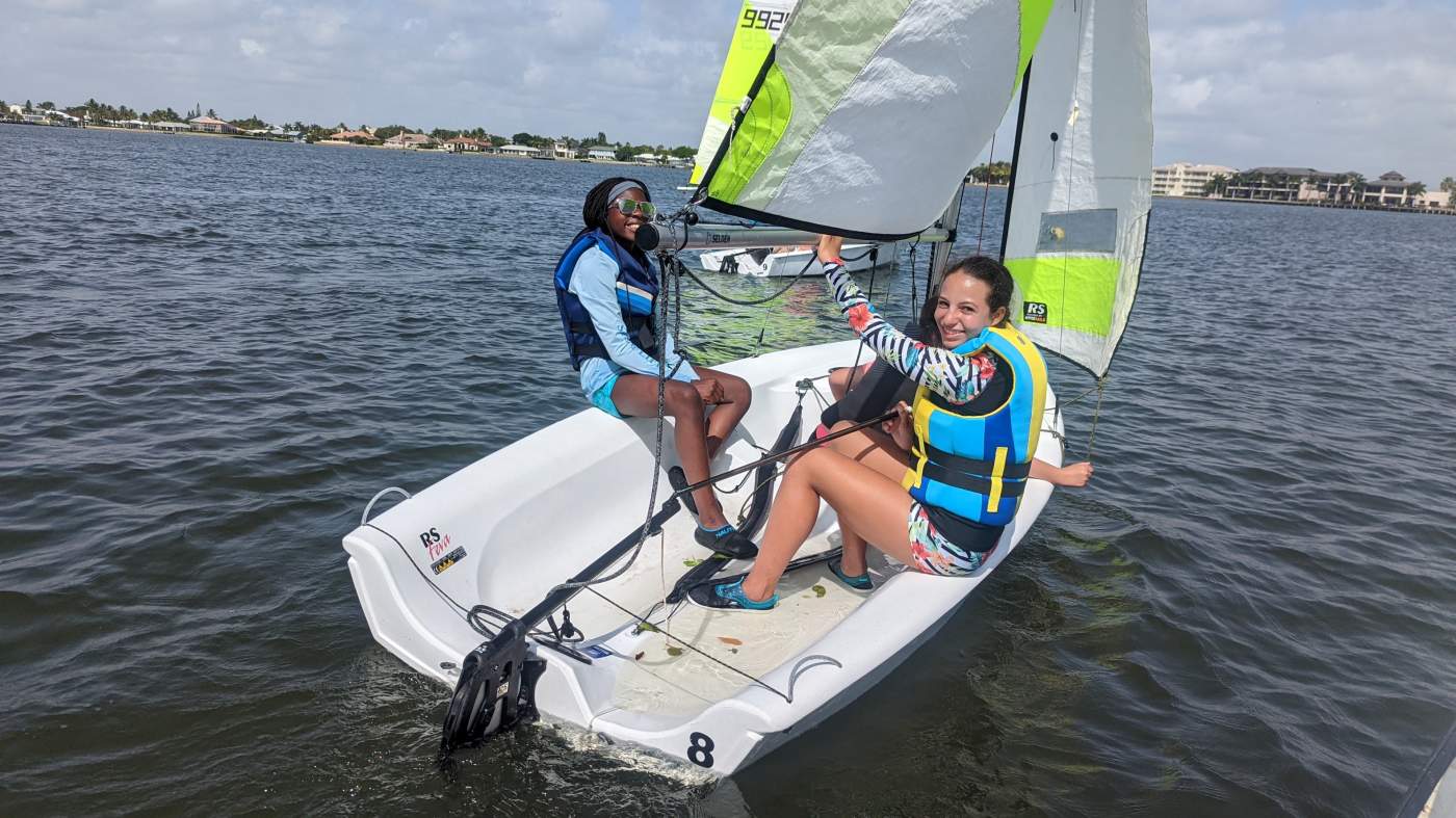 Three girls sailing a boat