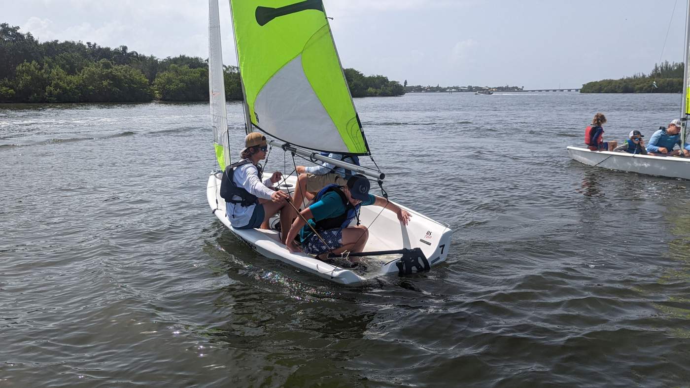 Three boys sailing a boat