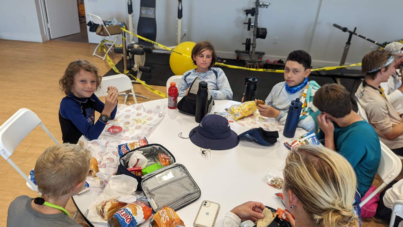 A group of children seated around several tables, having a snack
