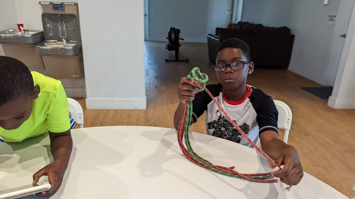 Several young men practicing knot tying