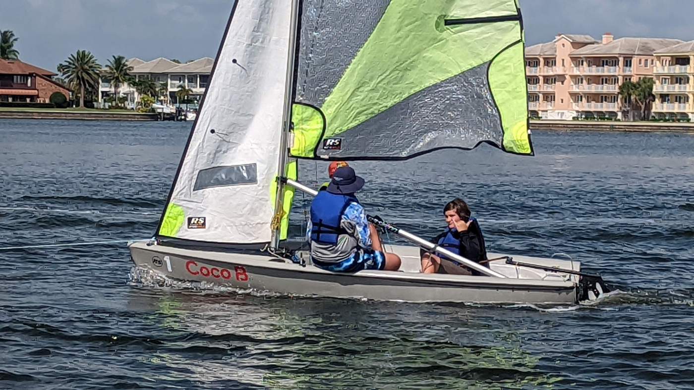 Three boys sailing a boat